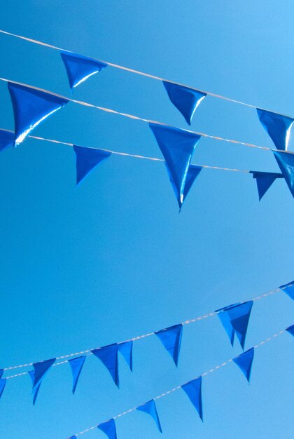 Niedrigwinkelansicht von Flaggen gegen einen klaren blauen Himmel