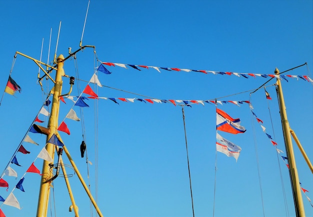 Foto niedrigwinkelansicht von flaggen vor klarem blauem himmel