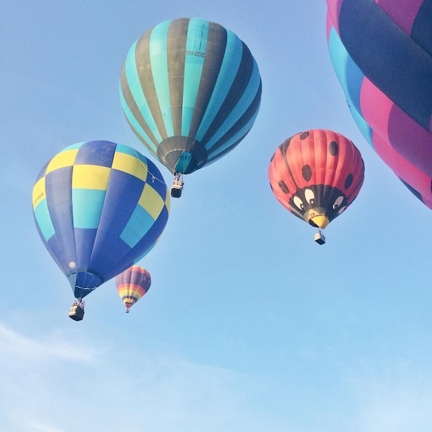 Niedrigwinkelansicht von Heißluftballons gegen den blauen Himmel