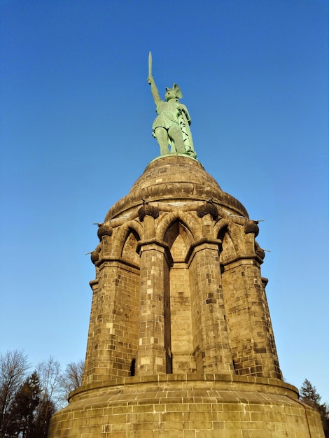 Foto niedrigwinkelansicht von hermannsdenkmal vor klarem blauen himmel