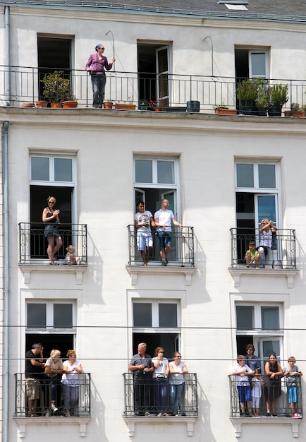 Foto niedrigwinkelansicht von menschen, die an einem sonnigen tag auf dem balkon stehen