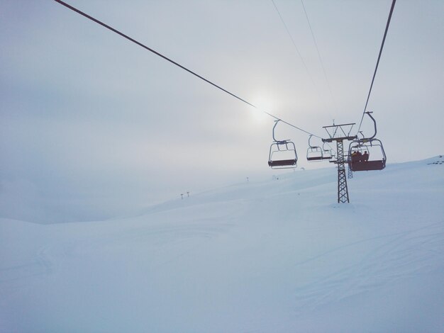 Foto niedrigwinkelansicht von skiliften auf einem schneebedeckten berg gegen den himmel im winter