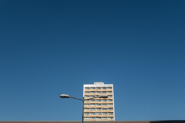 Niedrigwinkelansicht von Straßenleuchten und Wohngebäuden vor einem klaren blauen Himmel