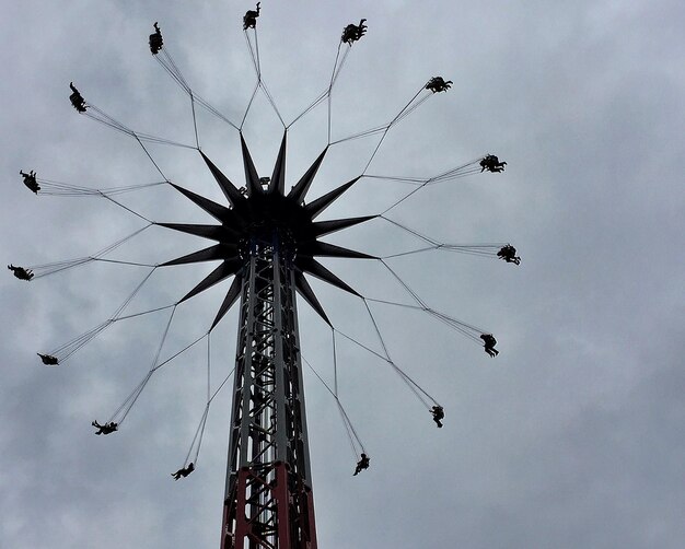 Foto niedrigwinklige sicht auf eine ketten-swing-fahrt gegen einen bewölkten himmel