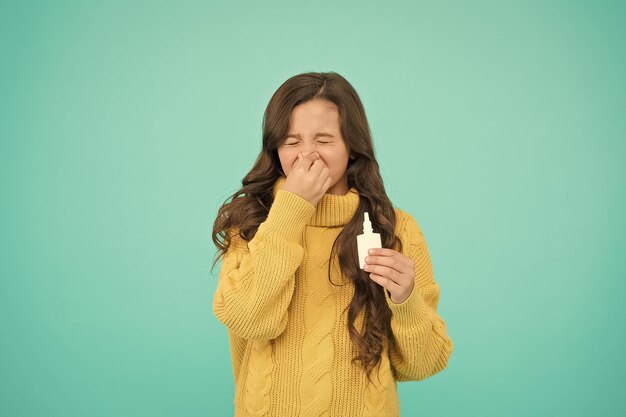 Niesen kind verwenden wirksame medikamente mädchen halten nasentropfen allergie-konzept behandlung zu hause nasentropfen plastikflasche effektives nasenspray grippe-konzept laufende nase und andere symptome einer erkältung