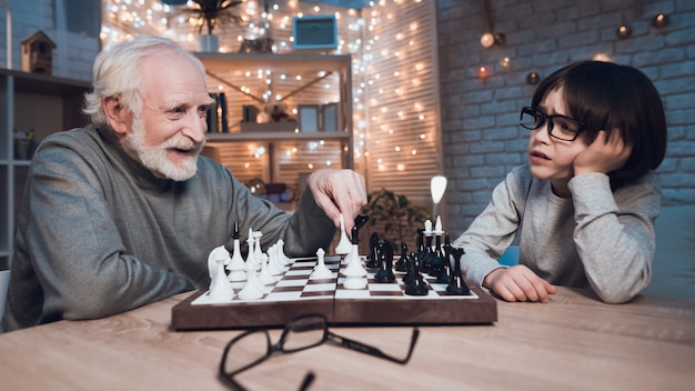 Nieto y abuelo jugando al ajedrez juntos