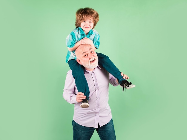 Nieto niño y abuelo piggyback paseo con cara graciosa aislado