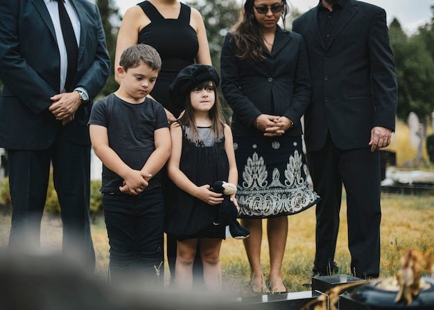 Foto nietos tristes de pie junto a la tumba