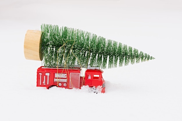 Nieve del árbol de navidad del coche. Entrega de juguetes, estado de ánimo de Año Nuevo, regalos en un auto rojo en miniatura para niños