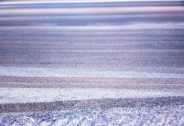 Nieve en la carretera de invierno con fondo de huellas de ruedas