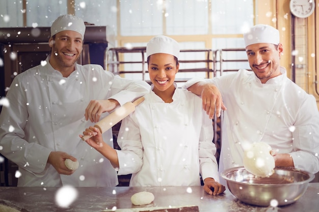 Foto nieve contra el equipo de panaderos sonriendo a la cámara