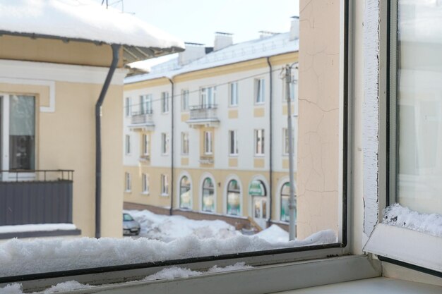 Nieve y hielo en las ventanas y techos de los edificios Fuertes nevadas en la ciudad