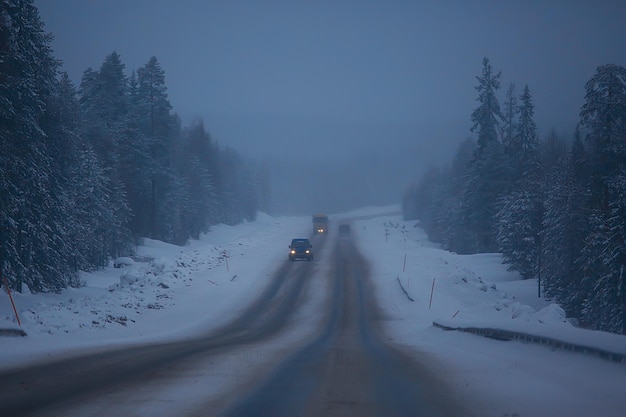 nieve y niebla en el paisaje de la carretera de invierno / vista del clima estacional una carretera peligrosa, un paisaje solitario de invierno