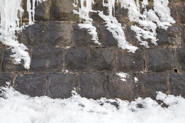 nieve en la pared de piedra