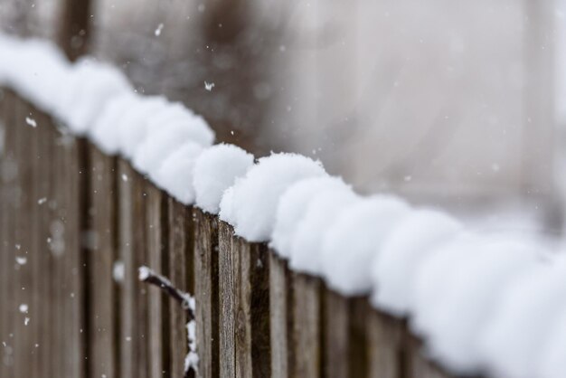 Nieve que cae sobre el fondo de una antigua valla de madera un paisaje rústico de invierno