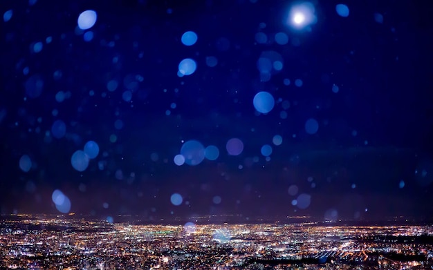 La nieve sobre el paisaje urbano iluminado contra el cielo nocturno