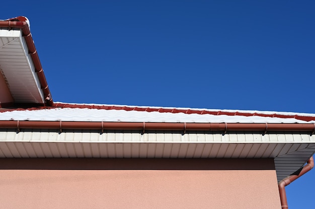 La nieve del techo de una casa particular se derrite al sol. Foto de alta calidad