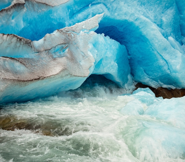 Nigardsbreen-gletscher-fußhöhle und schmelzender eisstrom nahaufnahme, jostedal, norwegen. schönes natürliches gletschereis und fluss, der hintergrundökologie und reisekonzept beginnt.