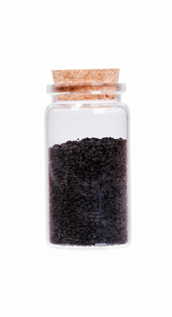 Nigella o comino negro en una botella de vidrio con tapón de corcho isol