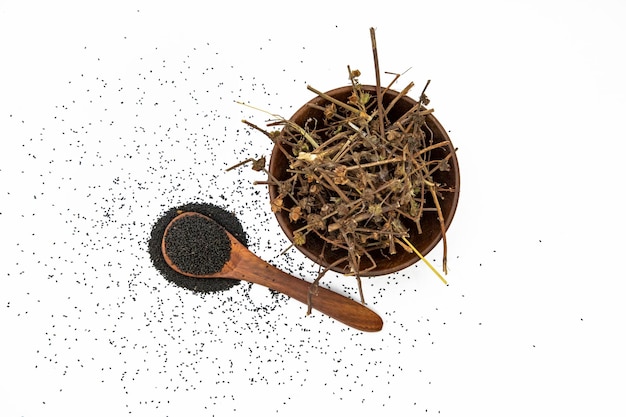 Nigella o comino negro con semillas medicinales de tulsi sobre fondo blanco.