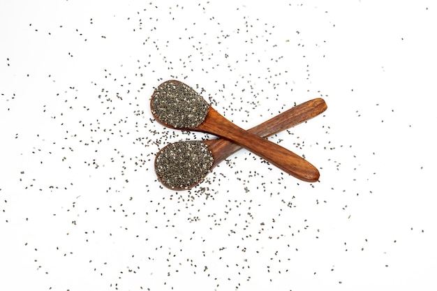 Nigella oder Schwarzkümmel mit einem medizinischen Tulsi Seeds WhiteBackground Brown Spoon