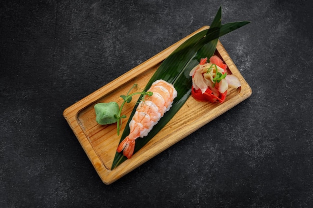 Nigiri Ebi sobre tabla de madera con wasabi y jengibre