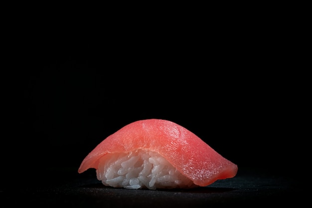 Nigiri de sushi clásico con atún sobre piedra oscura