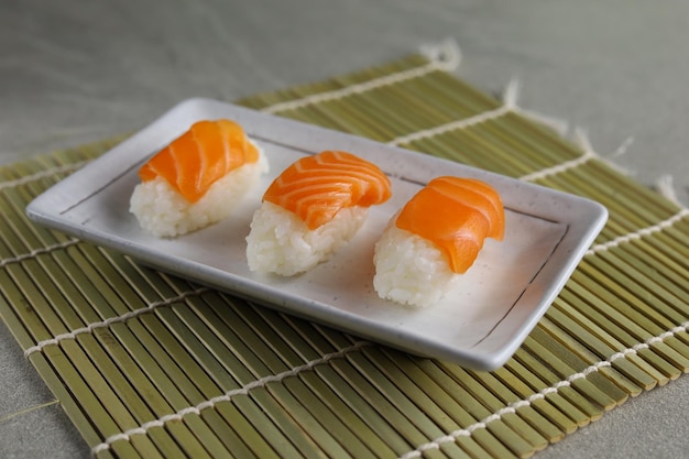 Nigiri de sushi de salmón fresco servido en plato de cerámica