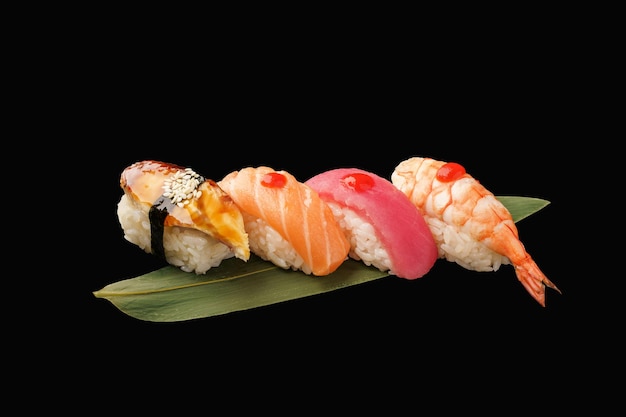 Nigiri sushi set nigiri anguila salmón atún camarones en una hoja de plátano comida japonesa sobre fondo negro aislado menú japonés