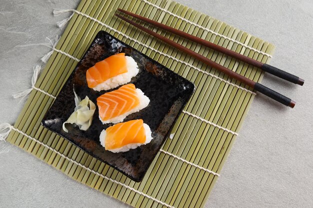 Niguiri de sushi de salmão fresco servido em prato de cerâmica