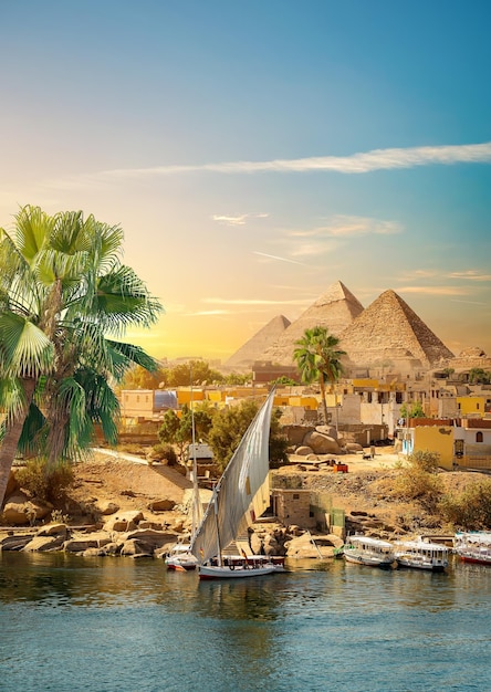 Nil und Boote bei Sonnenuntergang in Aswan und Pyramiden