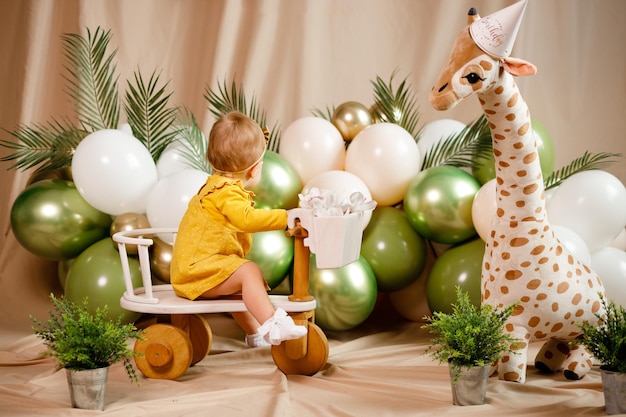Foto una niña de 1 año está jugando con juguetes en su cumpleaños en casa con un fondo marrón