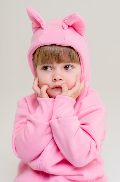 Niña de 3 años en un traje rosa con orejas