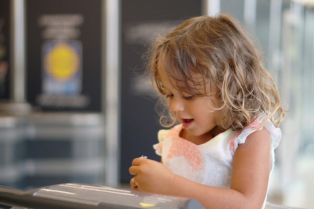 Una niña de 4 años mira el huevo de chocolate en un supermercado