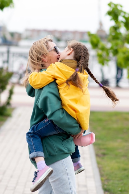 Una niña de 5-6 años de paseo con su madre. Es primavera afuera. Estilo de vida.