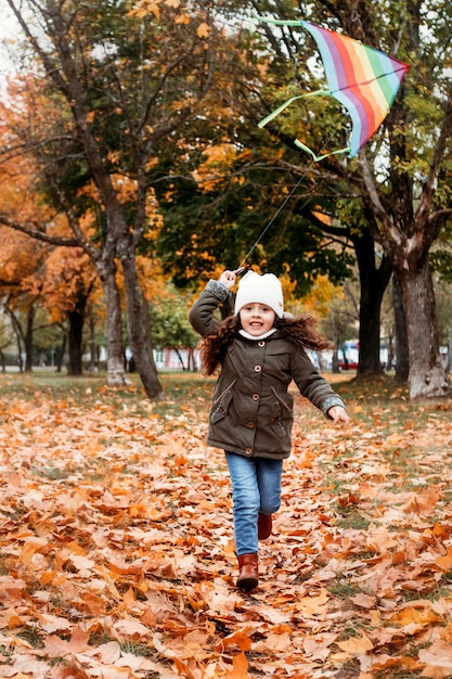 Niña de 5 años divirtiéndose en el bosque de otoño