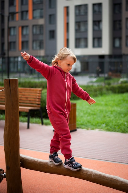 Niña de 5 años con un mono rojo juega en un simulador de deportes