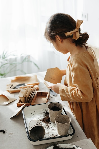 Niña de 6 años plantando hierbas en casa.