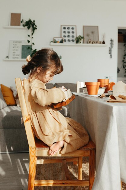 Niña de 6 años plantando hierbas en casa.