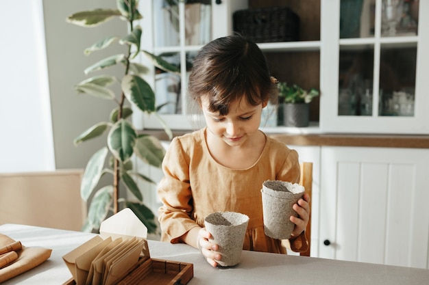 Niña de 6 años plantando hierbas en casa.