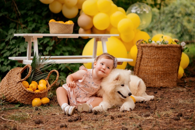 niña abraza a un perro samoyedo