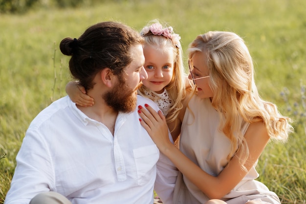 niña abraza a sus padres. felicidad. picnic de verano