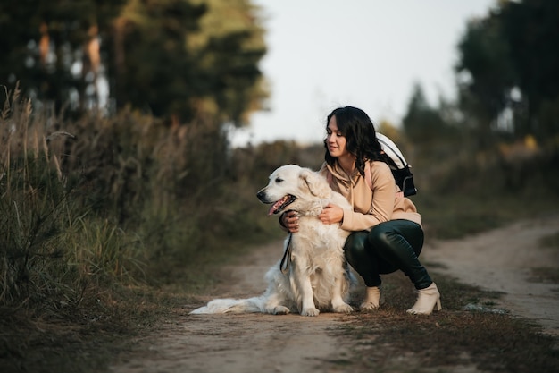 niña abrazando a un perro golden retriever en el bosque