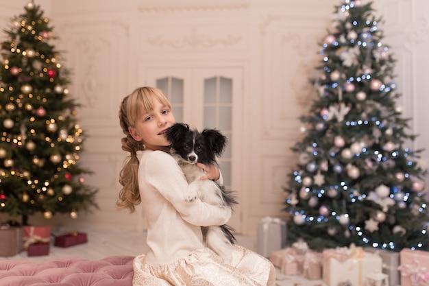 Niña abrazando a un perro que recibió como regalo de Navidad