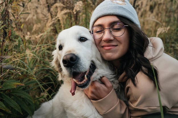 Foto niña, abrazar, blanco, golden retriever, perro, en el campo