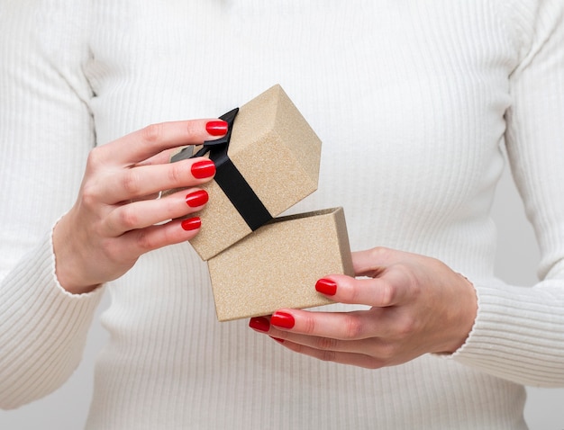 A la niña se abre maravillosamente para empacar el regalo en una elegante caja con una cinta.