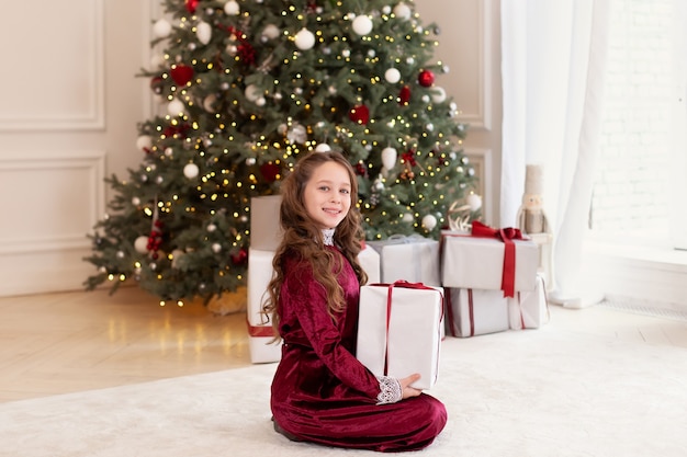 Niña abre presente en salón en Navidad