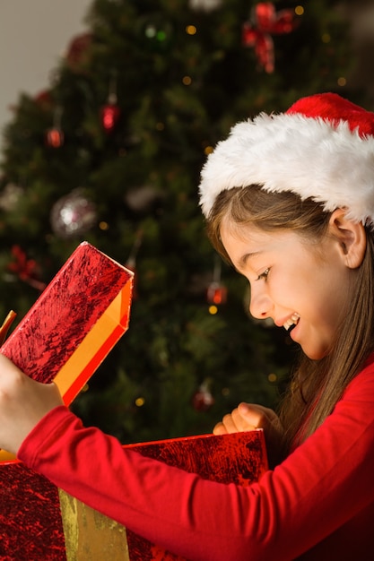 Niña abriendo un regalo mágico de Navidad