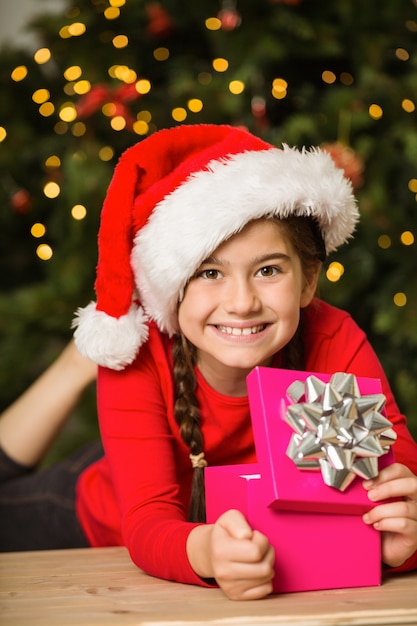 Niña abriendo un regalo en Navidad