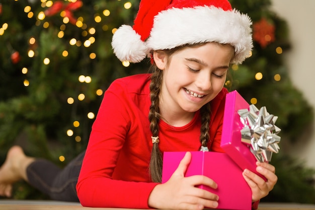 Niña abriendo un regalo en Navidad